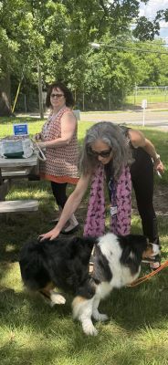 Dr. Gagliardi petting a dog outside at an event