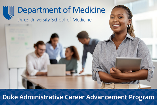 A young Black woman holds a notebook and smiles at the camera, her peers are behind her gathered around a computer. The DOM logo is overlaid on the image