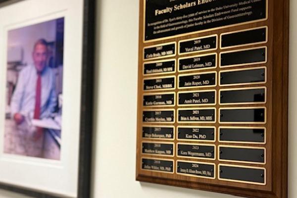 Photo of Dr. Tyor and plaque with previous award winners names'