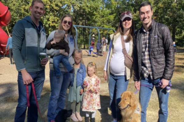 Residents standing outside with their families at a park. 