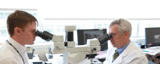 Duke oncologists looking in microscope