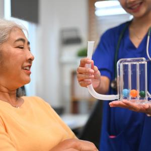 a doctor shows a patient a lung exerciser 